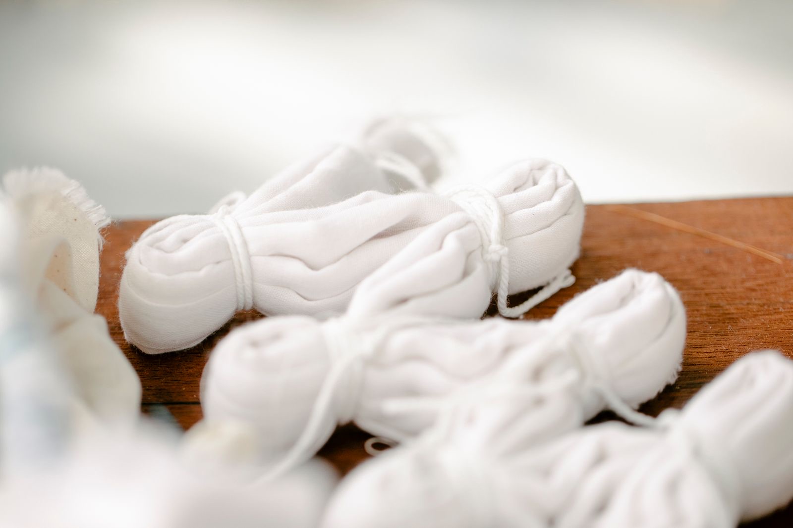 White cotton pieces folded and tied with string, ready for dye