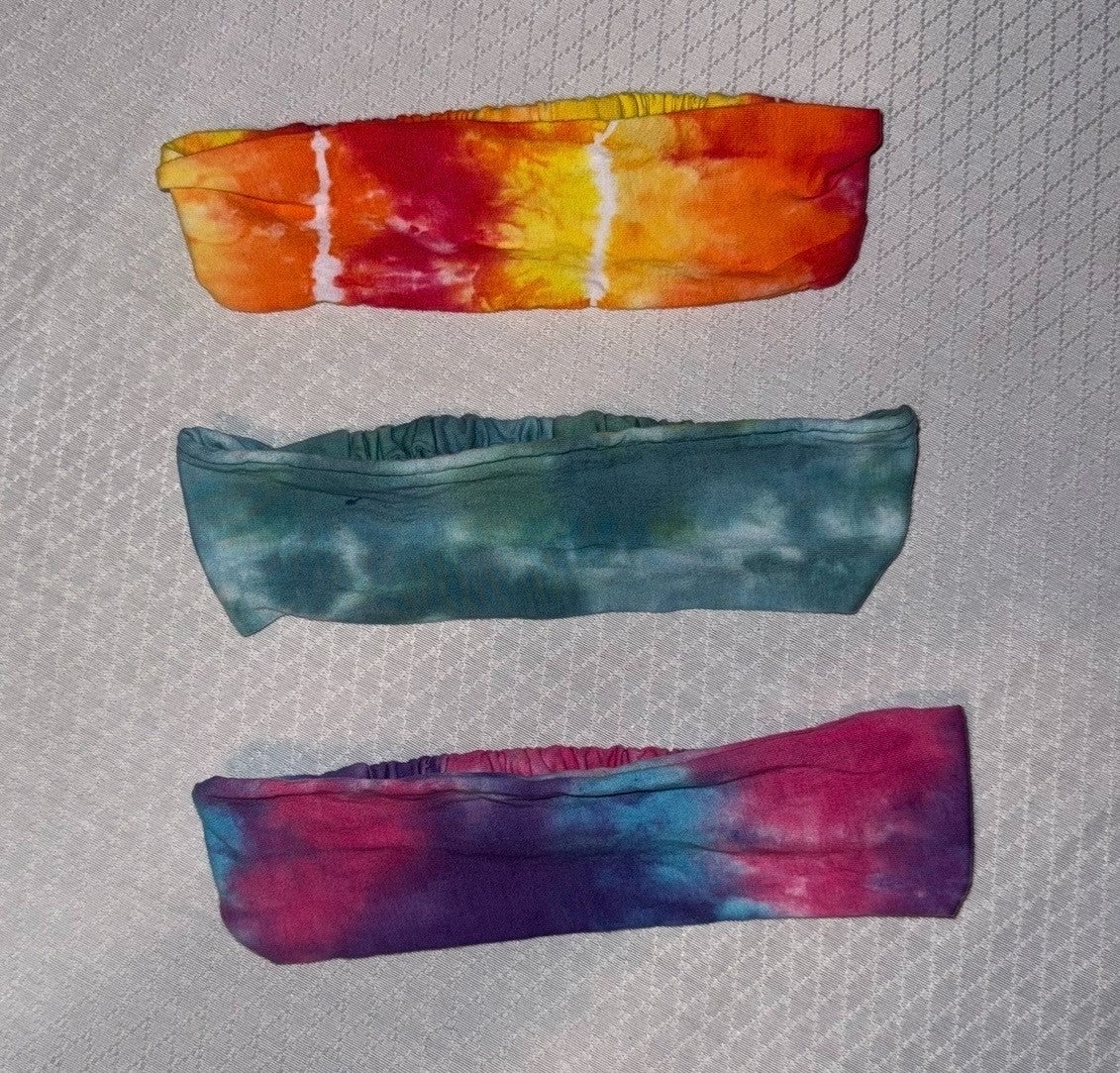 Three tie-dye headbands in orange, teal and purple