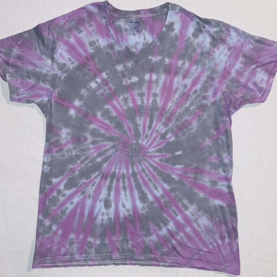 Purple and grey spiral tie-dye V-neck T-shirt laid flat